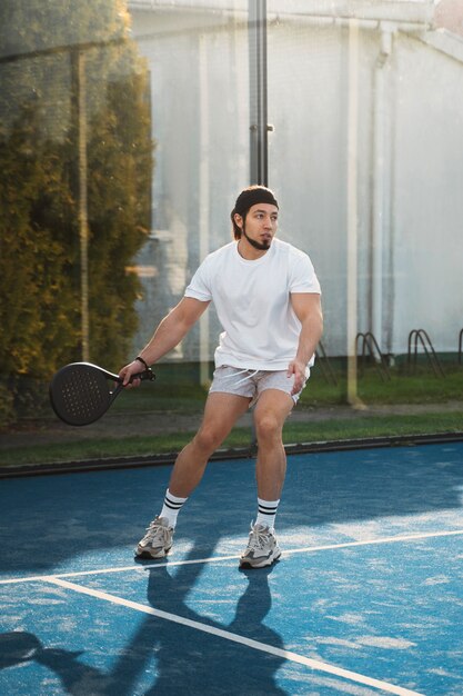 Homme jouant au paddle-tennis plein coup