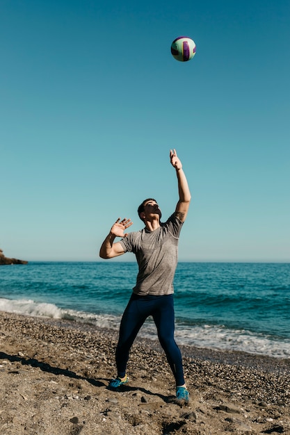 Photo gratuite homme jouant au volleyball à la plage