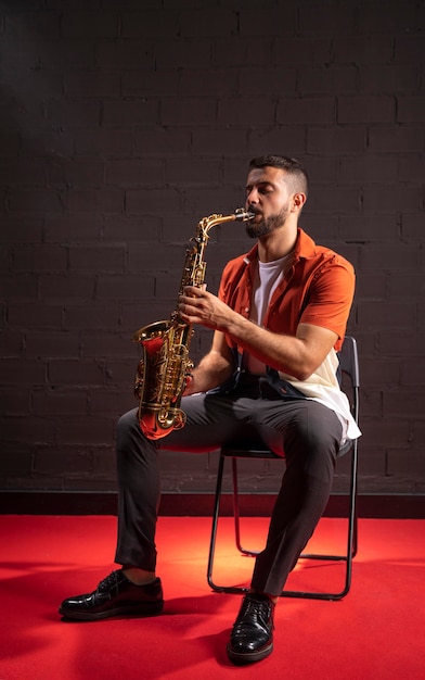 Homme jouant du saxophone en position assise