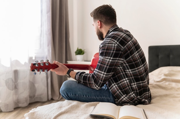 Homme jouant de la guitare coup moyen