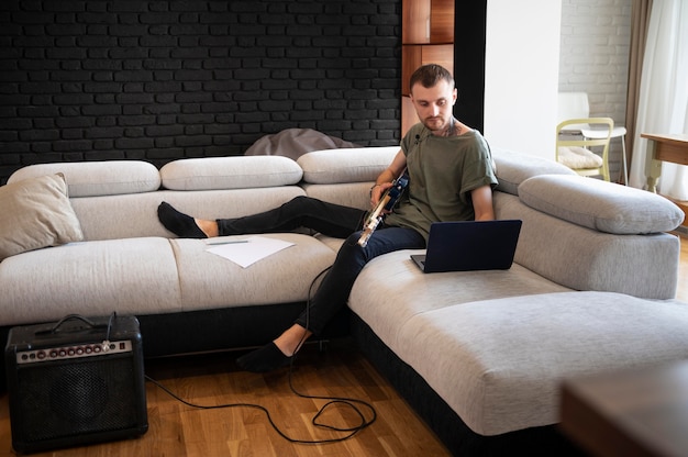 Homme jouant de la guitare à la maison