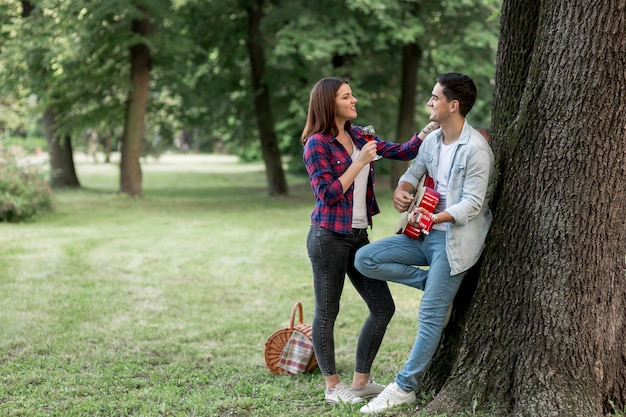 Homme jouant de la guitare pour sa petite amie