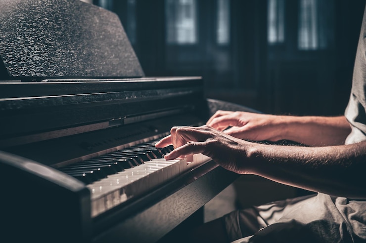 Photo gratuit un homme joue d'un piano électronique dans une pièce sombre