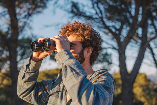 Homme avec des jumelles dans la nature