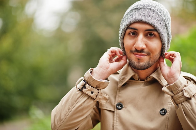 Homme koweïtien élégant au trench-coat et au chapeau