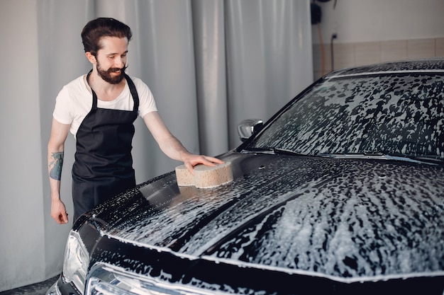 Photo gratuite homme lave sa voiture dans un garage