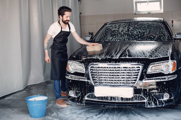 Homme lave sa voiture dans un garage