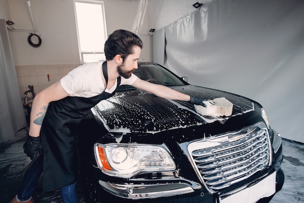 Homme lave sa voiture dans un garage