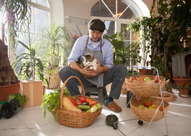 Homme avec des légumes qui ont été cultivés et cultivés à l'intérieur