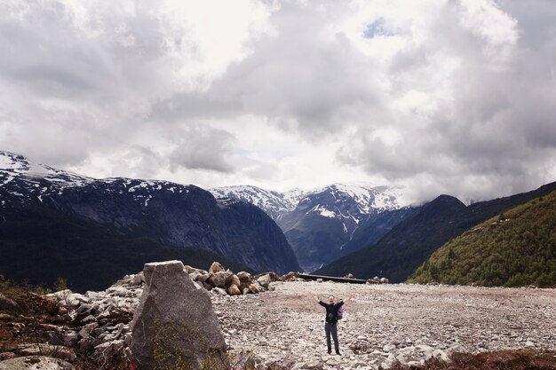 L&#39;homme lève les mains en posant devant de magnifiques montagnes en Norvège