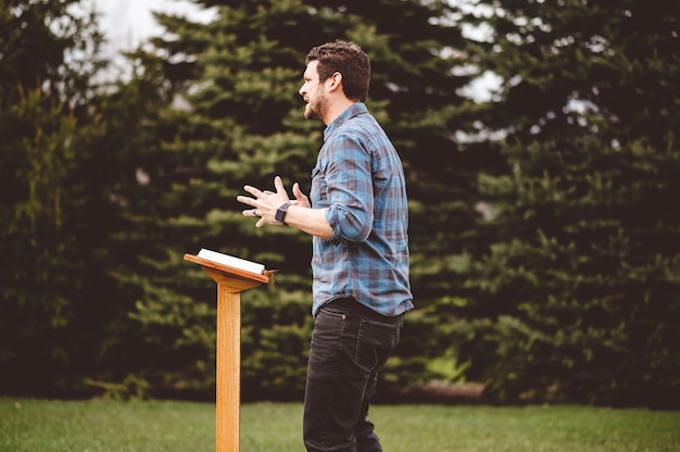 Un homme lisant la bible en se tenant près du podium