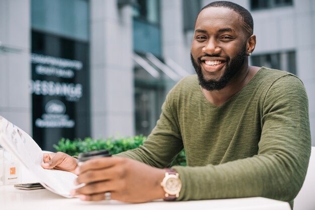 Homme lisant un journal au café