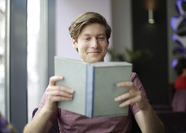 Homme lisant un livre au café