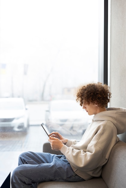 Photo gratuite homme lisant la vue latérale du magazine numérique