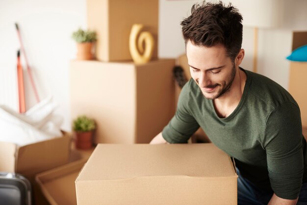 Homme avec une lourde boîte en carton