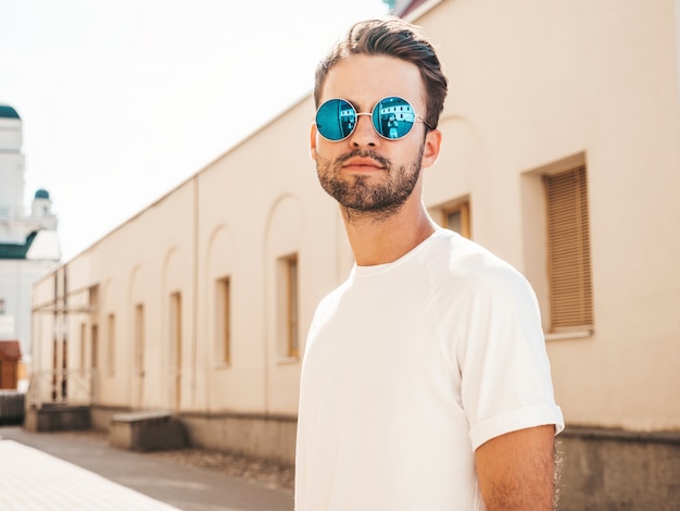 Photo gratuite homme avec des lunettes de soleil portant un t-shirt blanc posant