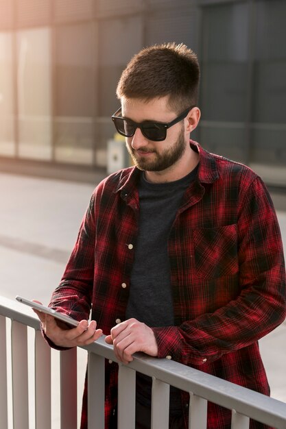 Photo gratuite homme avec des lunettes de soleil sur un smartphone