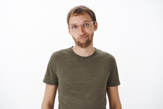 Homme à lunettes et t-shirt décontracté vert souriant sympathique debout détendu et calme