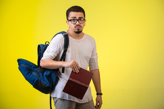 Homme avec des lunettes tenant un livre.