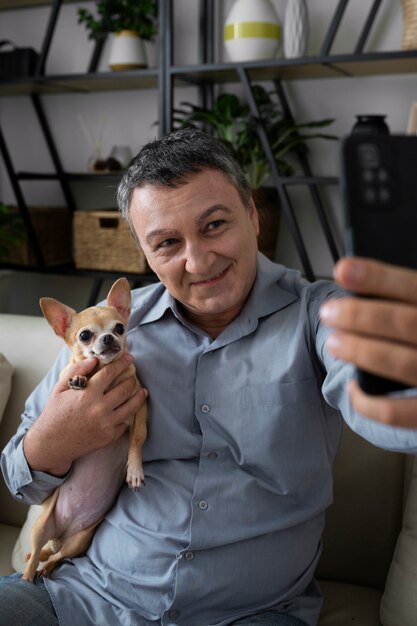 Homme à la maison prenant un selfie avec son chien