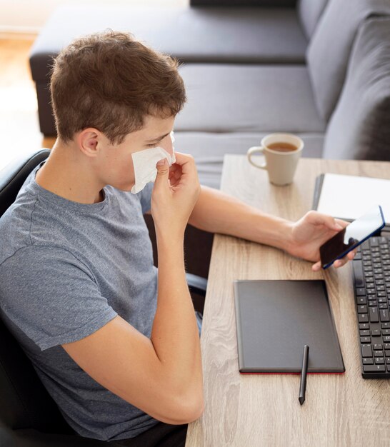 Homme à la maison en quarantaine vérifiant le smartphone et travaillant