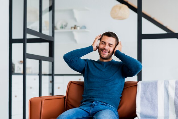 Homme à la maison se détendre et écouter de la musique