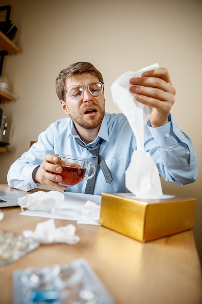 Photo gratuite homme malade alors qu'il travaillait au bureau, homme d'affaires attrapé froid, grippe saisonnière.