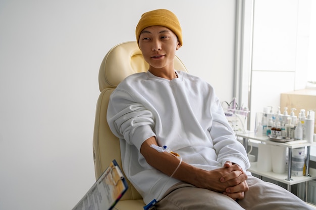 Homme malade assis sur une chaise coup moyen
