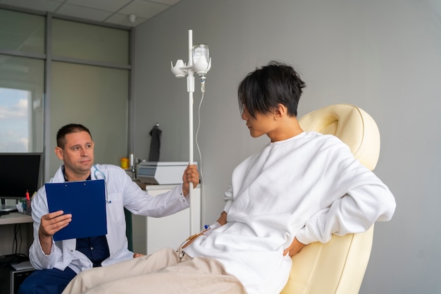 Photo gratuite homme malade assis sur une chaise vue de côté