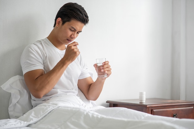 Photo gratuite un homme malade sur le canapé et sur le point de prendre des antibiotiques.