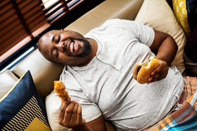 Homme mangeant un gros hamburger