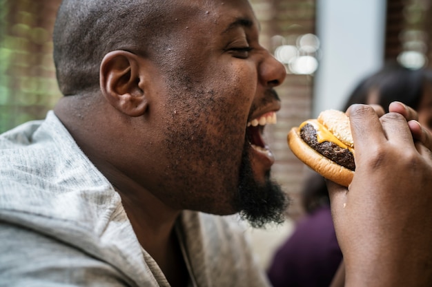 Homme mangeant un gros hamburger