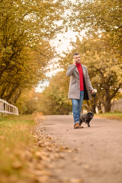 Homme marchant avec un chien dans un parc