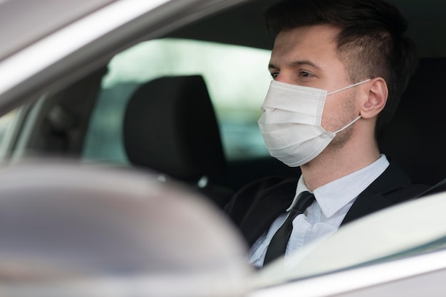 Homme avec masque au volant