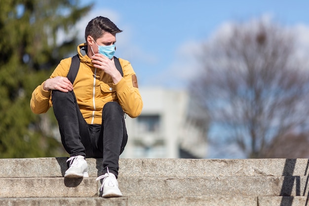 Photo gratuite homme avec masque chirurgical en plein air