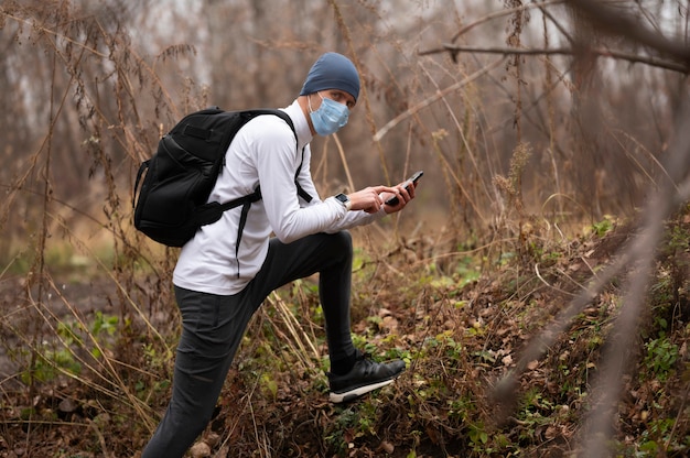 Homme avec masque facial dans les bois