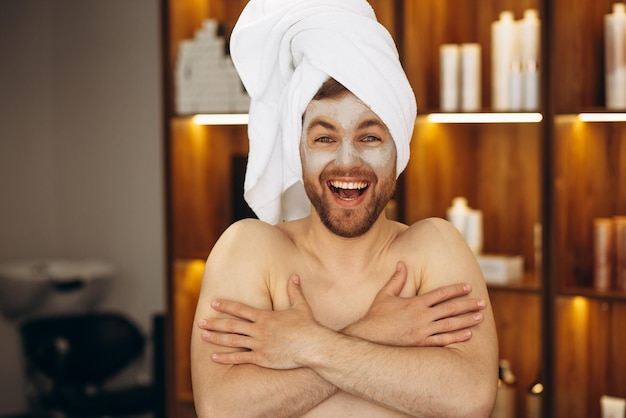 Photo gratuite homme avec masque hydratant et serviette sur la tête