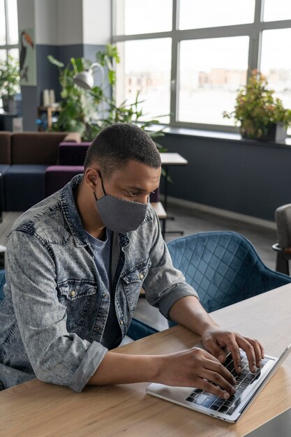 Homme avec masque médical travaillant