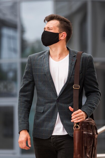 Homme avec masque pendant la pandémie sur le chemin du travail