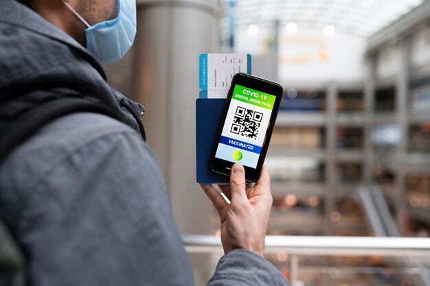 Homme avec masque tenant un smartphone