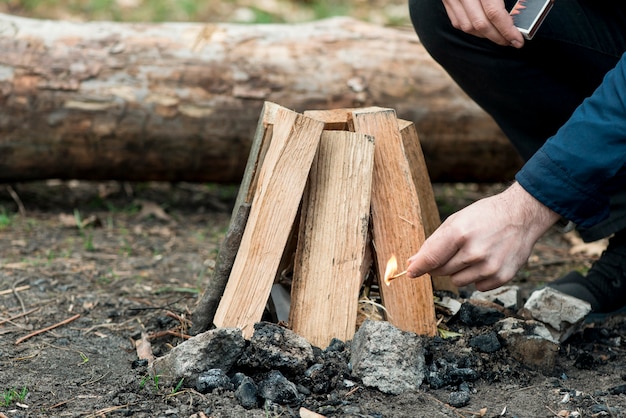 Homme avec match faisant feu de joie