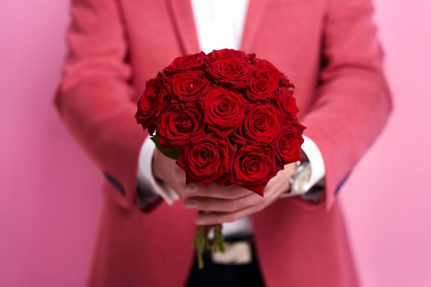 Photo gratuite homme méconnaissable donnant un bouquet de rose