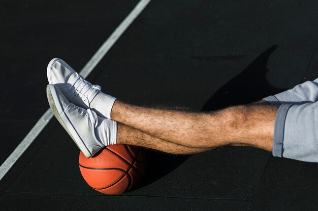 Homme méconnaissable se détendre sur un terrain de basket