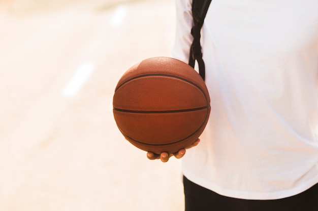 Photo gratuite homme méconnaissable tenant la vue de face de basket-ball