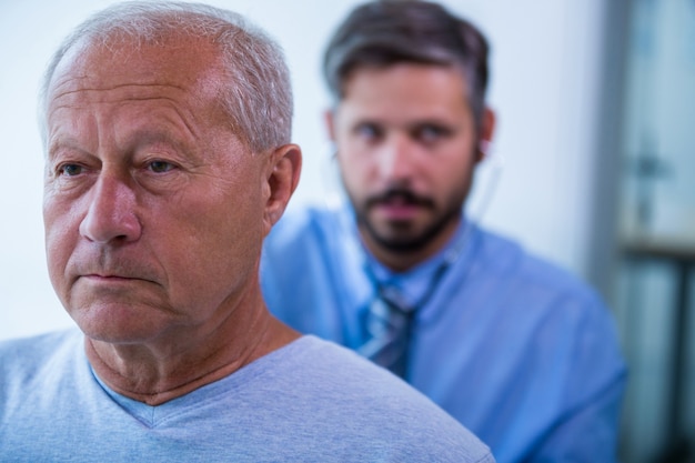 Homme médecin examine un patient