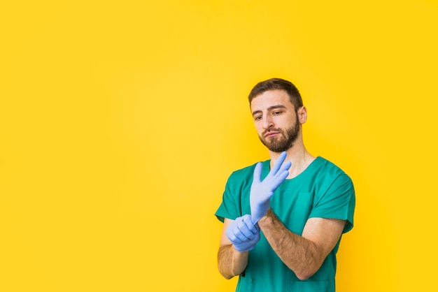 Homme médecin met des gants stériles