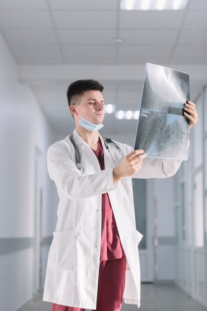 Homme médecin avec radiographie en clinique