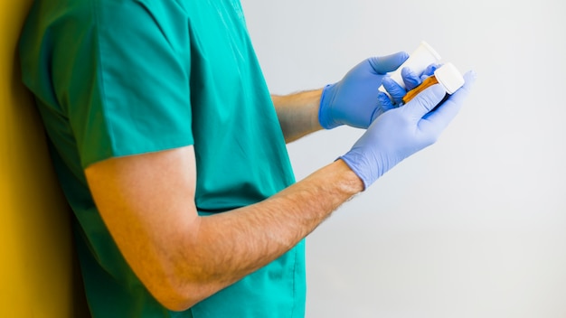 Homme médecin tenant des bouteilles de médicament dans les mains