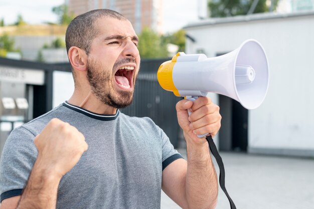 Homme avec mégaphone criant à la protestation