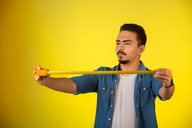 Homme mesurant la longueur par règle et à la recherche attentive.